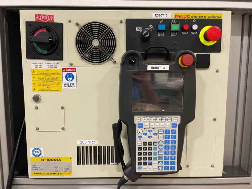 A close-up image of the refurbished Fanuc R-30iB+ controller. The controller features a ipendant with touchscreen display, 4D graphics, and the latest handling tool software.